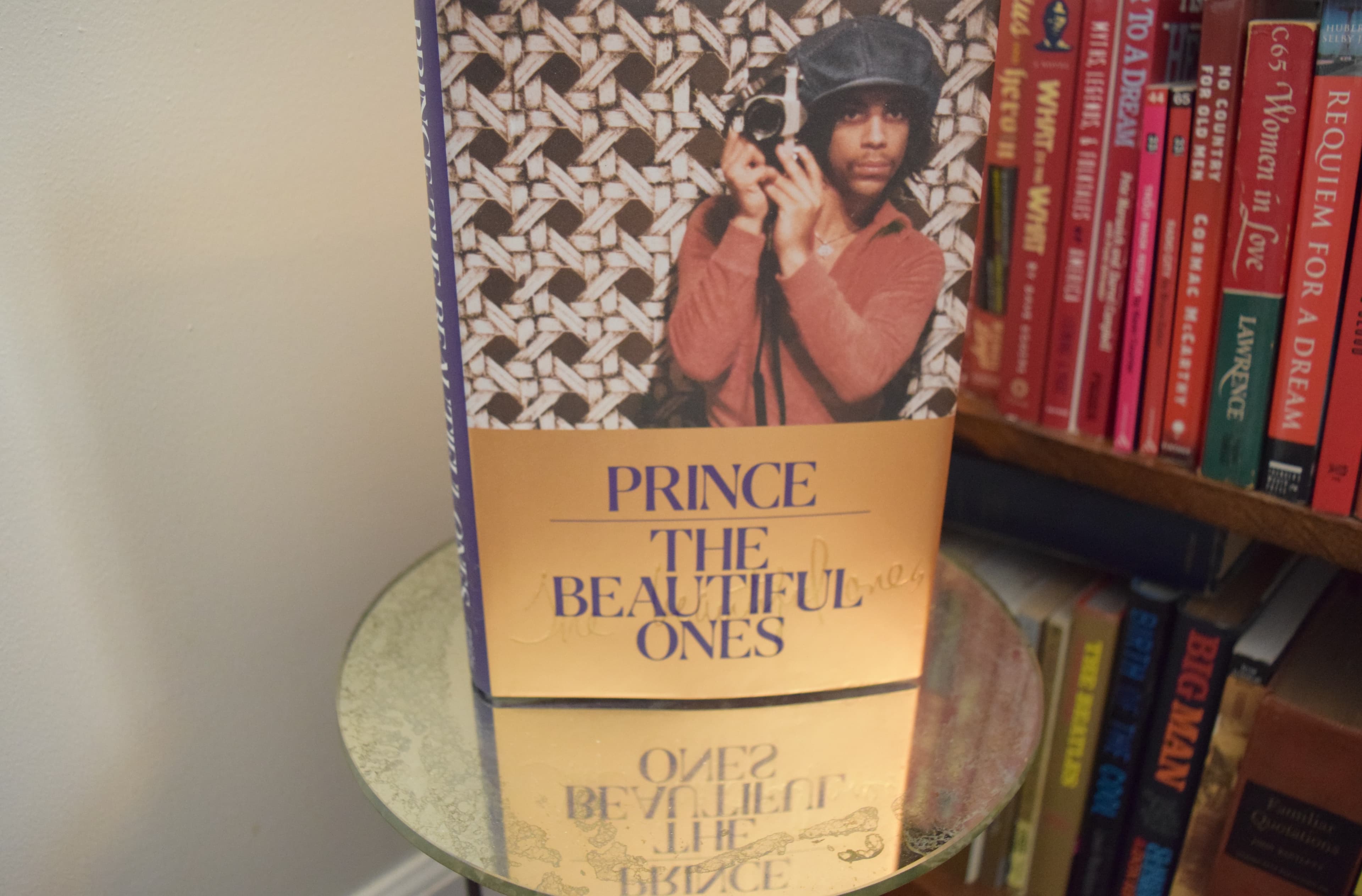 Prince: The Beautiful Ones, on a shelf of books